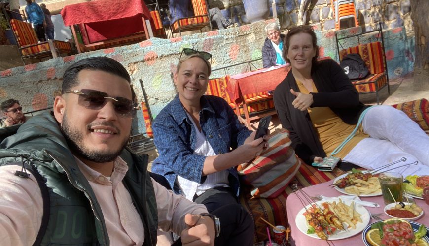 Travelers enjoying mint tea with locals in a traditional riad during authentic tours Marrakech cultural experiences
