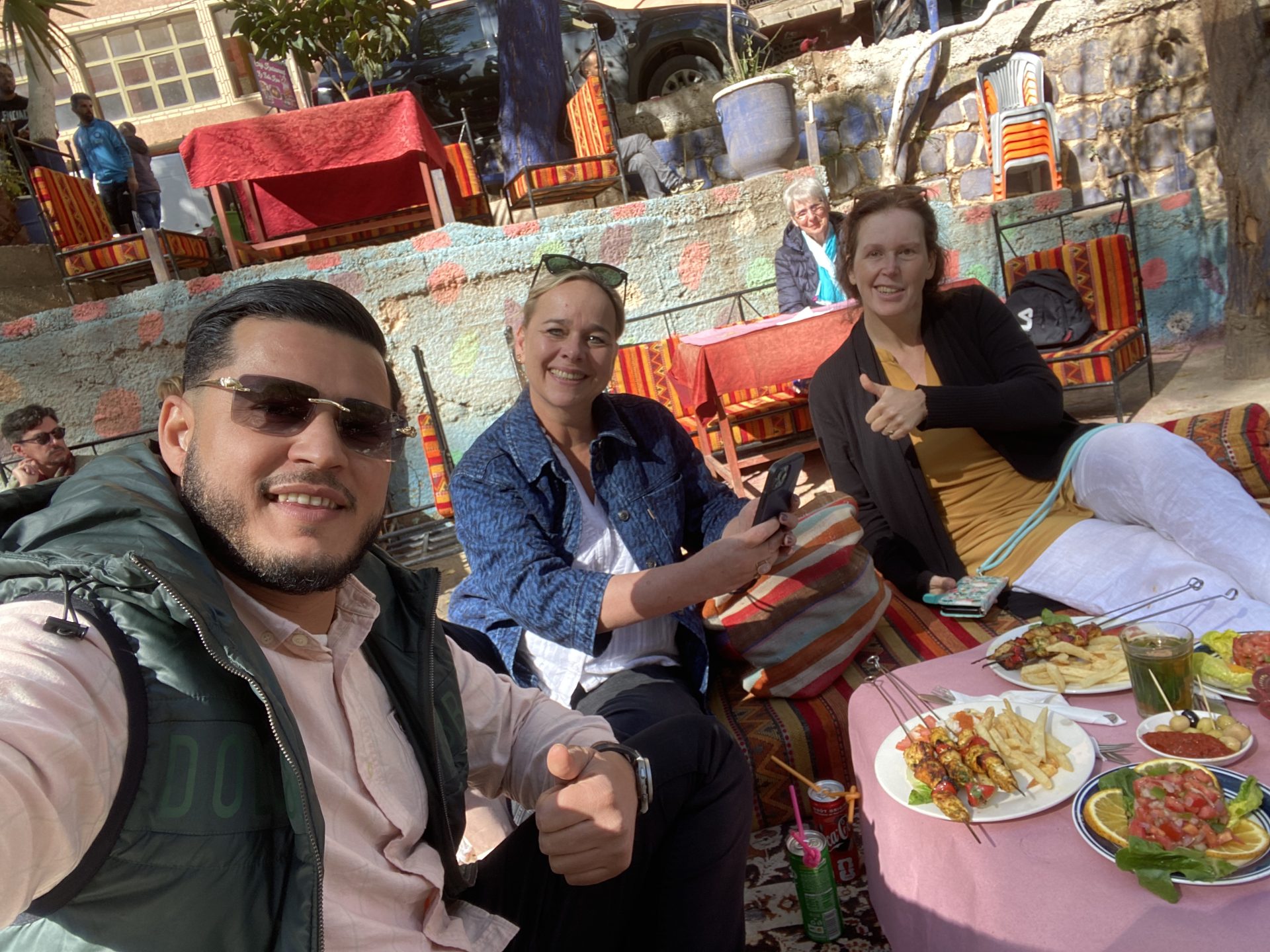 Travelers enjoying mint tea with locals in a traditional riad during authentic tours Marrakech cultural experiences