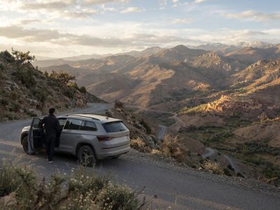 Travelers reviewing a car rental with driver budget on a terrace in Morocco