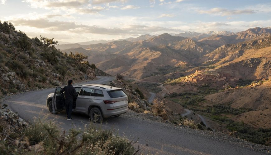 Travelers reviewing a car rental with driver budget on a terrace in Morocco