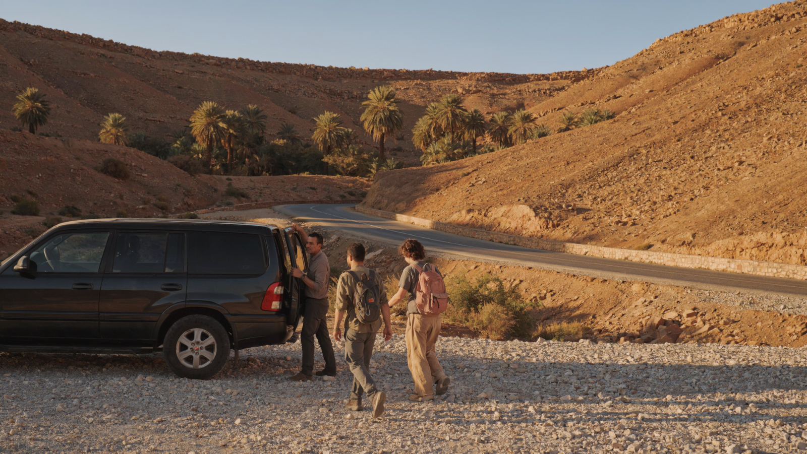 A private vehicle parked on a desert road near Ouarzazate during a scenic excursion from Ouarzazate