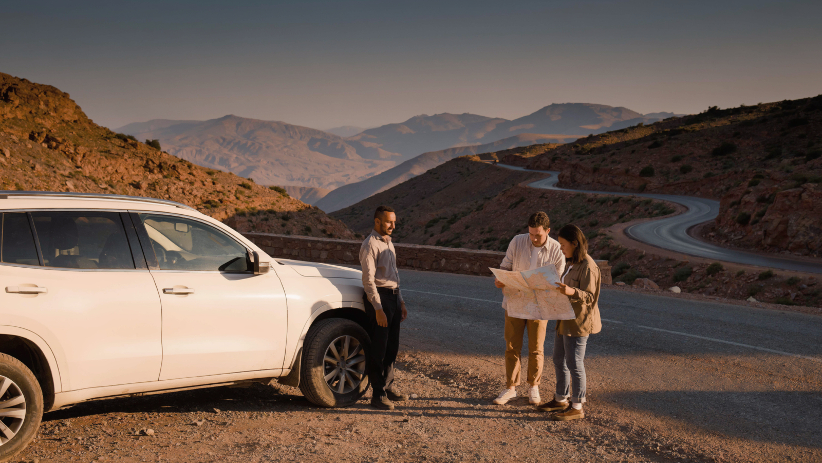 Travelers planning Morocco driver tours with a private driver beside a mountain road