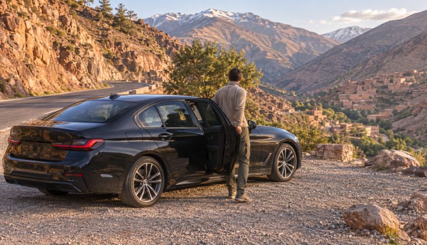 Private Morocco Driver waiting beside a comfortable car on a scenic mountain road