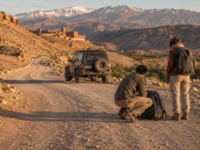 Travelers discussing questions with a Private Morocco Driver beside a comfortable vehicle in Morocco