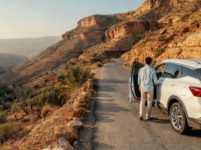 Private Morocco Driver waiting beside a car on a scenic road in Morocco
