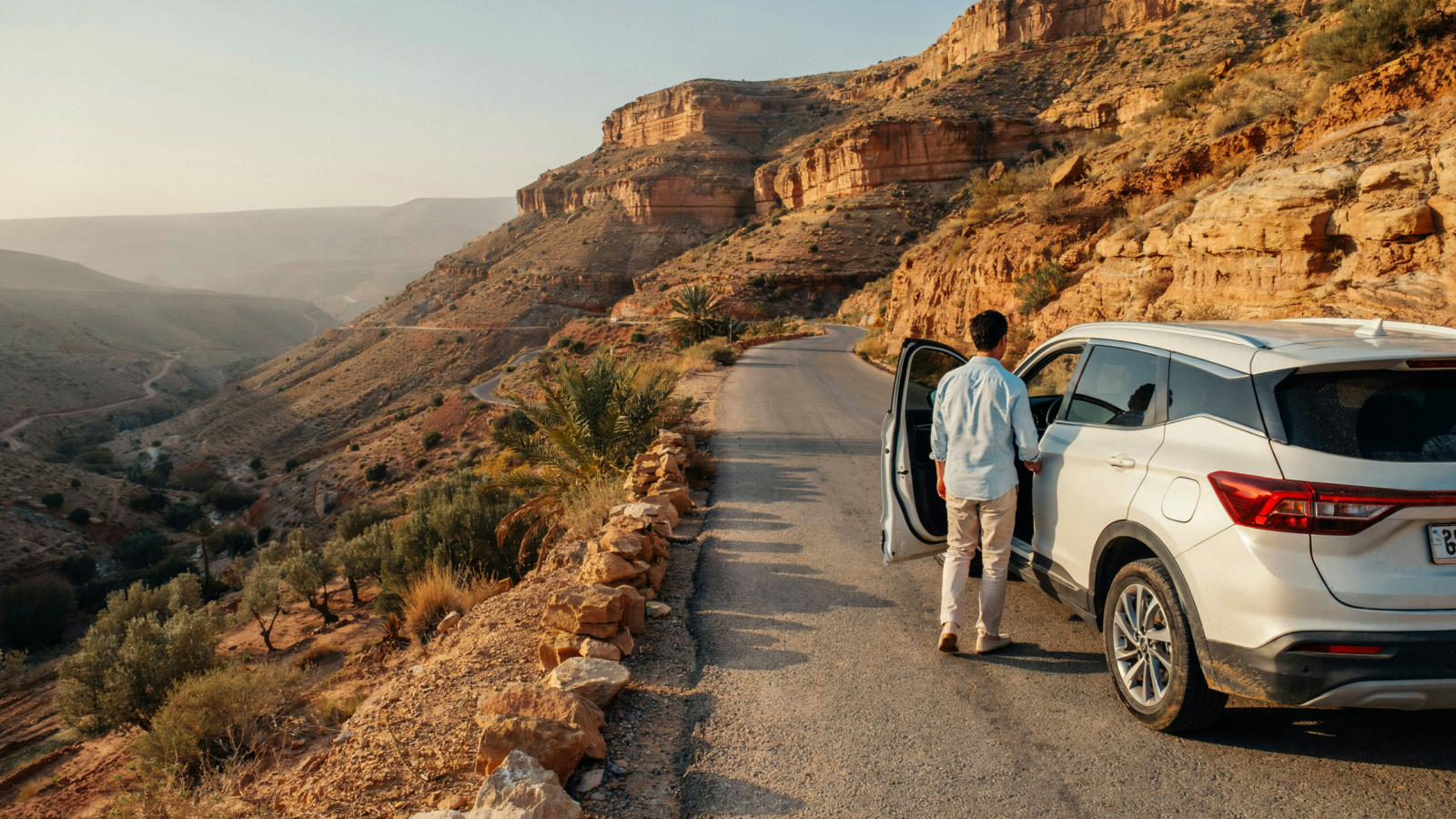 Private Morocco Driver waiting beside a car on a scenic road in Morocco